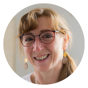 Ein rundes Porträt von Heidi Siegert, einer lächelnden Frau mit rötlich blonden Haaren, Brille und runden Ohrringen, die Energiearbeit in Bautzen anbietet.